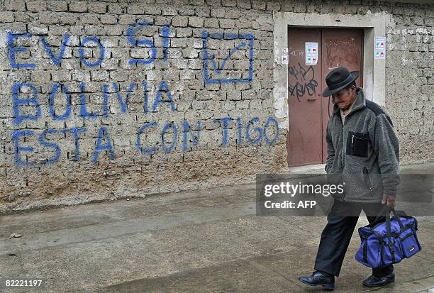 Local passes by a wall with a graffiti supporting Bolivian President Evo Morales for next Sunday's referendum, on August 8, 2008 in El Alto, Bolivia....