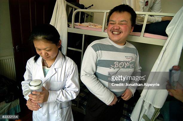 Zhen and her friend, also from Inner Mongolia, are laughing at a joke, on March 12, 2008 in Beijing, China. Most of the blind workers share rooms, as...