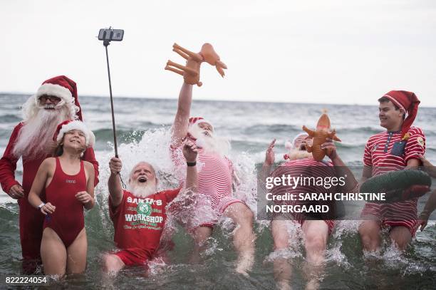 Santas jump for a picture into the water at the amusement park Dyrehavsbakken in Klampenborg, north of Copenhagen on July 25, 2017. Since 1957,...