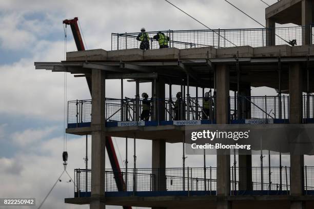 Workers build residential flats on the Greenwich Peninsula construction site in London, U.K., on Tuesday, July 25, 2017. U.K. House prices are...