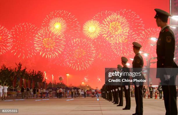 Fireworks light up the sky as paramilitary policemen stand guard during the Opening Ceremony for the Beijing 2008 Olympic Games on August 8, 2008 in...