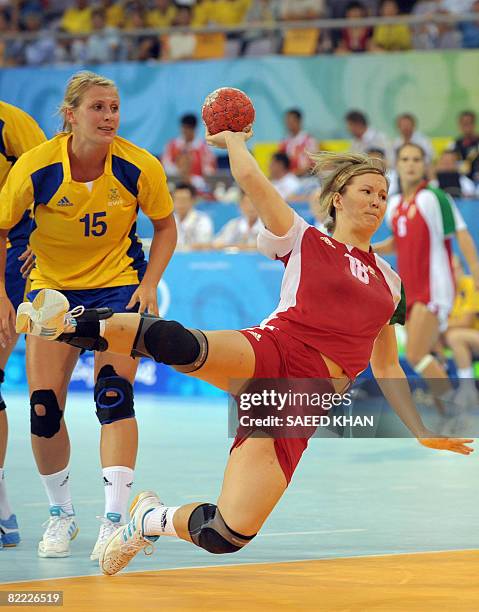 Piroska Szamoransky of Hungary shoots a goal after dodging Sweden's Johanna Ahlm during their 2008 Beijing Olympics Games women's handball match on...