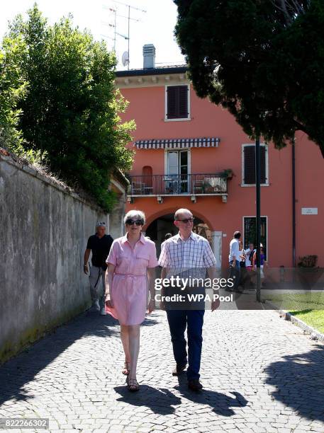 British Prime Minister Theresa May, left, walks with her husband Philip on July 25, 2017 in Desenzano del Garda, Italy. May is spending her holidays...