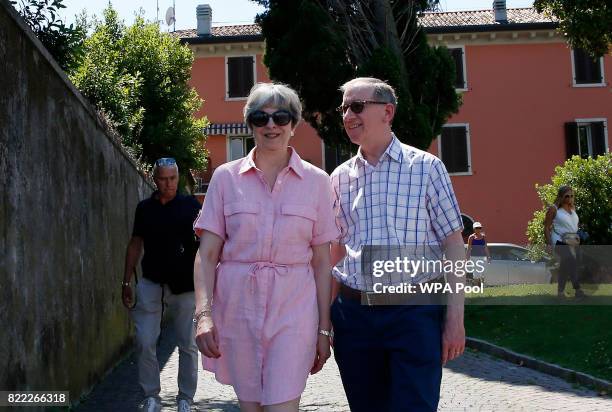 British Prime Minister Theresa May, left, walks with her husband Philip on July 25, 2017 in Desenzano del Garda, Italy. May is spending her holidays...