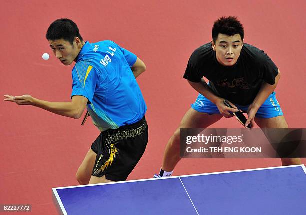 China's table tennis player's Wang Liqin and Wang Hao take part in a practice session at the Peking University Gymnasium in Beijing on August 9,...