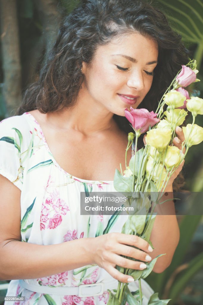 Linda mulher cheirando rosas