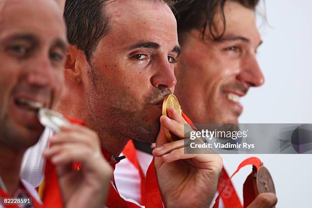 Silver medalist Davide Rebellin of Italy, gold medalist Samuel Sanchez of Spain and bronze medalist Fabian Cancellara of Switzerland stand on the...