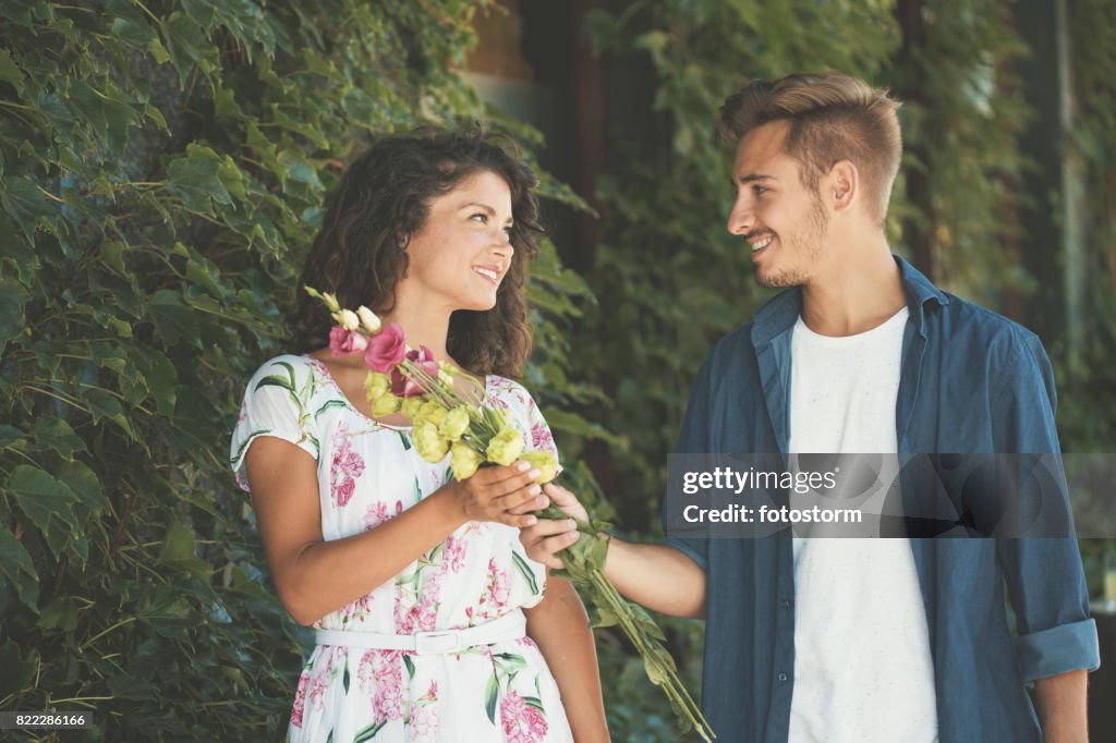 Young man in love giving flowers to his girlfriend