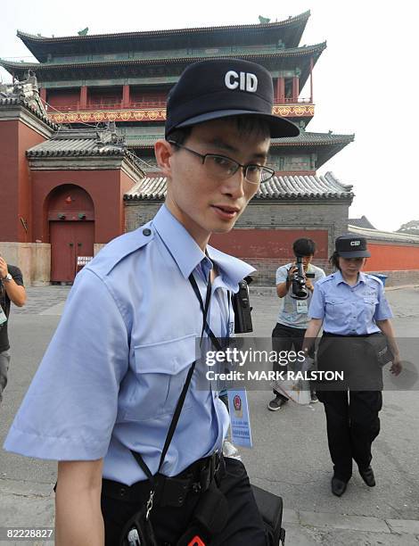 Chinese police forensic officers leaves the Drum Tower with evidence after investigating the scene where a US citizen was murdered in Beijing on...