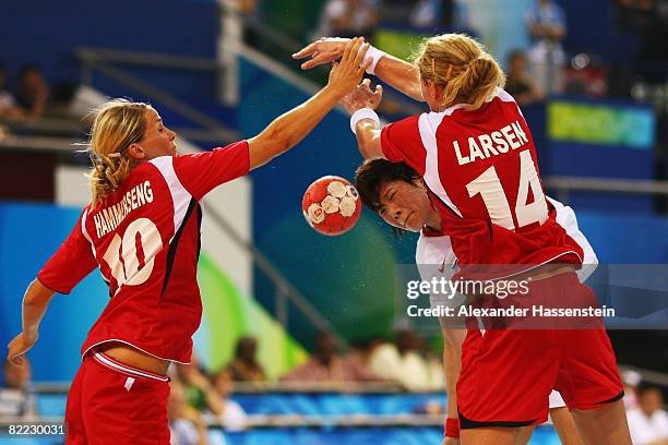 Liu Xiaomei of China is tackled by Tonje Larsen and Gro Hammerseng of Norway during the handball match between Norway and China held at the Olympic...