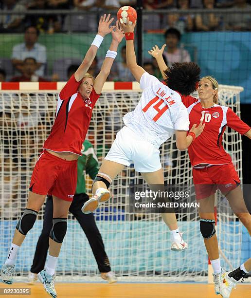 Norway's Tonje Larsen and Gro Hammerseng vie with China's attacker Liu Xiaomei during the women's preliminary handball match for the 2008 Olympics...