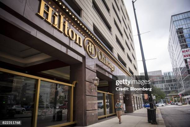 Pedestrian passes in front of the Hilton Chicago hotel in downtown Chicago, Illinois, U.S., on Monday, July 24, 2017. Hilton Worldwide Holdings Inc....