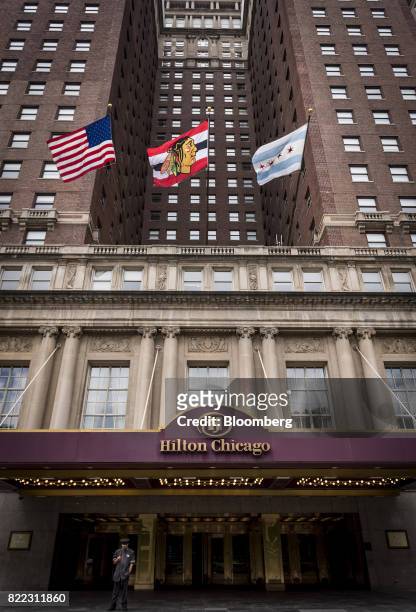 Flags fly outside the Hilton Chicago hotel in downtown Chicago, Illinois, U.S., on Monday, July 24, 2017. Hilton Worldwide Holdings Inc. Is scheduled...