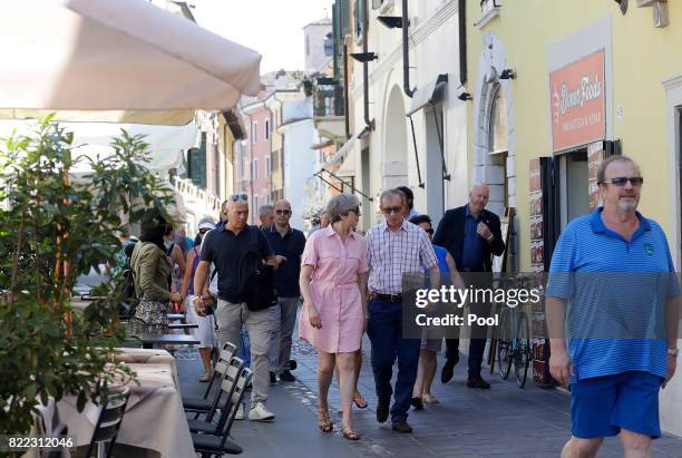 British Prime Minister Theresa May, left, walks with her husband Philip close to Lake Garda on July 25, 2017 in Desenzano del Garda, Italy. May is...