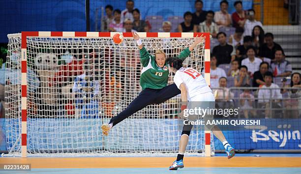 Norway's goalkeeper Gro Hammerseng tries to make a save as China's Li Weiwei throws the ball during the women's preliminary group A handball match...
