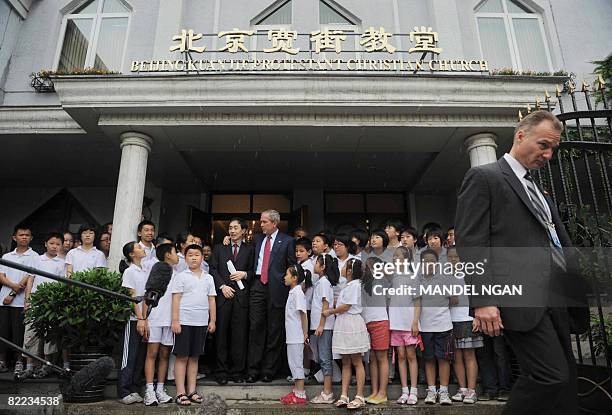 President George W. Bush stands next to Pastor Li Jian-An and the children's choir as he speaks after attending Sunday service at Beijing Kuanjie...