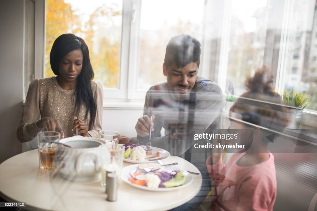 Young African American family having a lunch at home.