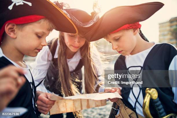 kinder spielen piraten am strand - seeräuber stock-fotos und bilder