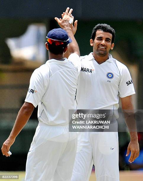 Indian cricketer Zaheer Khan celebrates with teammate Rahul Dravid the dismissal of unseen Sri Lankan batsman Prasana Jayawerdane during the third...