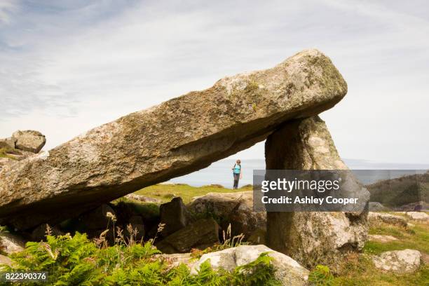 a burial chamber on st davids head, pembrokeshire, wales, uk, with a woman walker - doelman stock pictures, royalty-free photos & images
