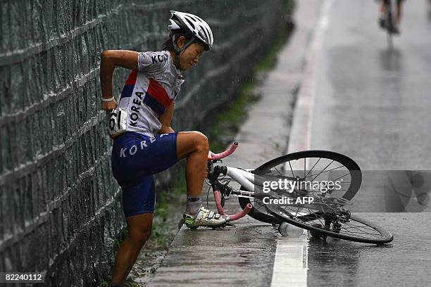 Gu Sungeun of South Korea gets back to her feet after falling during the women's road cycling event held on the Road Cycling Course of the Beijing...