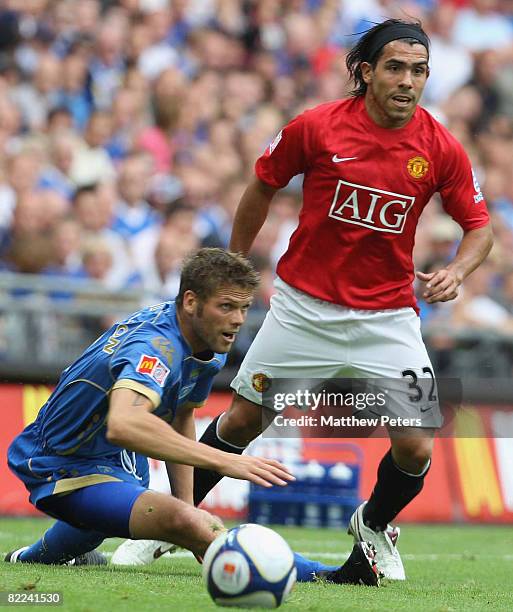 Carlos Tevez of Manchester United clashes with Hermann Hreidarsson of Portsmouth during the FA Community Shield match between Manchester United and...