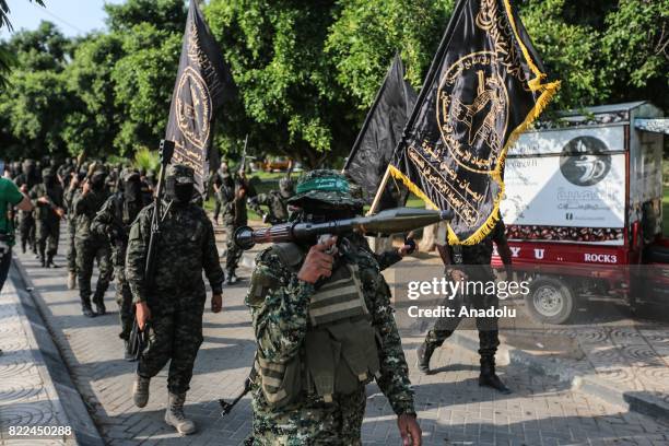 Members of Palestinian groups' armed wings march during a parade, organized to show their solidarity with the resistance against Israel's...