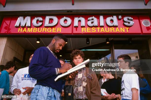 Charles Oakley of the New York Knicks signs autographs for fans before the 1990 McDonald's Open against Scavolini Pesaro at Palau Sant Jordi on...