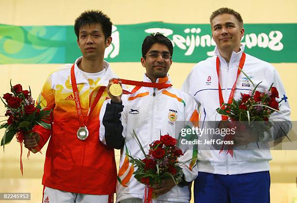 Silver medalist Zhu Qinan of China, Gold medalist Abhinav Bindra of India and Bronze medalist Henri Hakkinen of Finland pose after the Men's 10m Air...