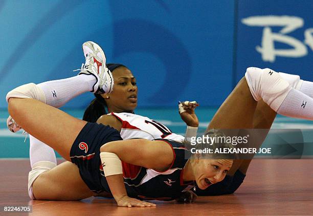 Nicole Davis and Kimberly Glass of US fall as they try to get to the ball as they play against Cuba during a 2008 Beijing Olympics Women's...
