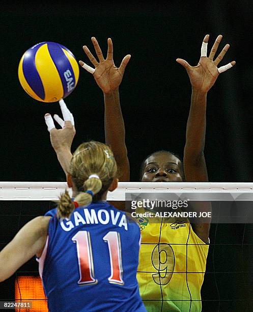 Ekaterina Gamova of Russia taps the ball past Fabiana Claudino of Brazil during the women's preliminary volleyball match 10 pool B event during the...