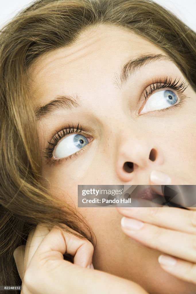 Woman covering mouth with hand,