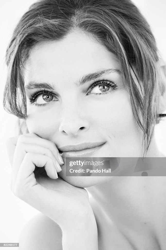 Woman looking up, head on hand, portrait