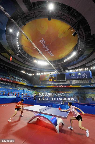 China's table tennis players Zhang Yining and Guo Yue take part in a practice session at the Peking University gymnasium on August 11, 2008 two days...