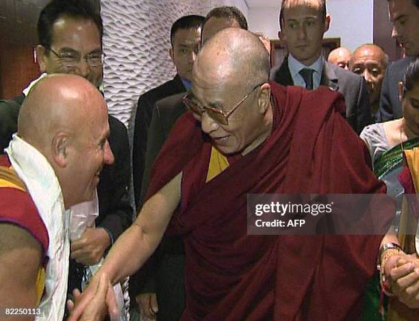 Grab released by the association "Ocean de sagesse" shows Tibetan spiritual leader, The Dalai Lama shaking hands with his French interpreter and...