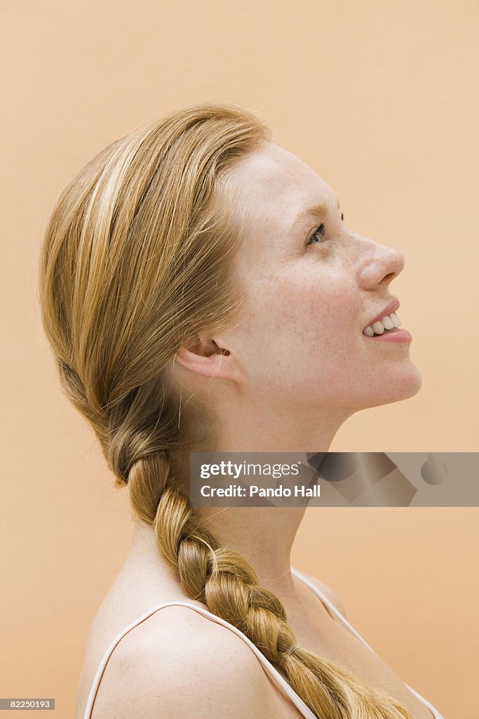 Woman smiling, looking up, side view