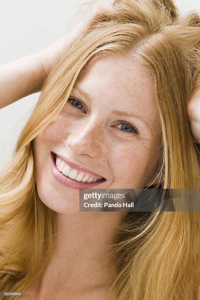 Young woman with hands in hair smiling