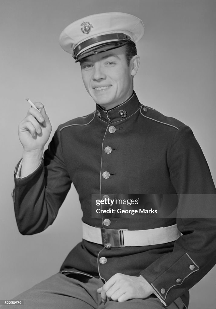 Young man in military uniform with cigarette, portrait