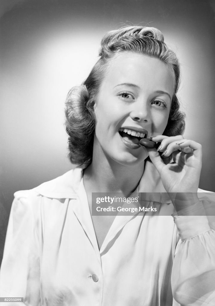 Young woman eating chocolate, portrait