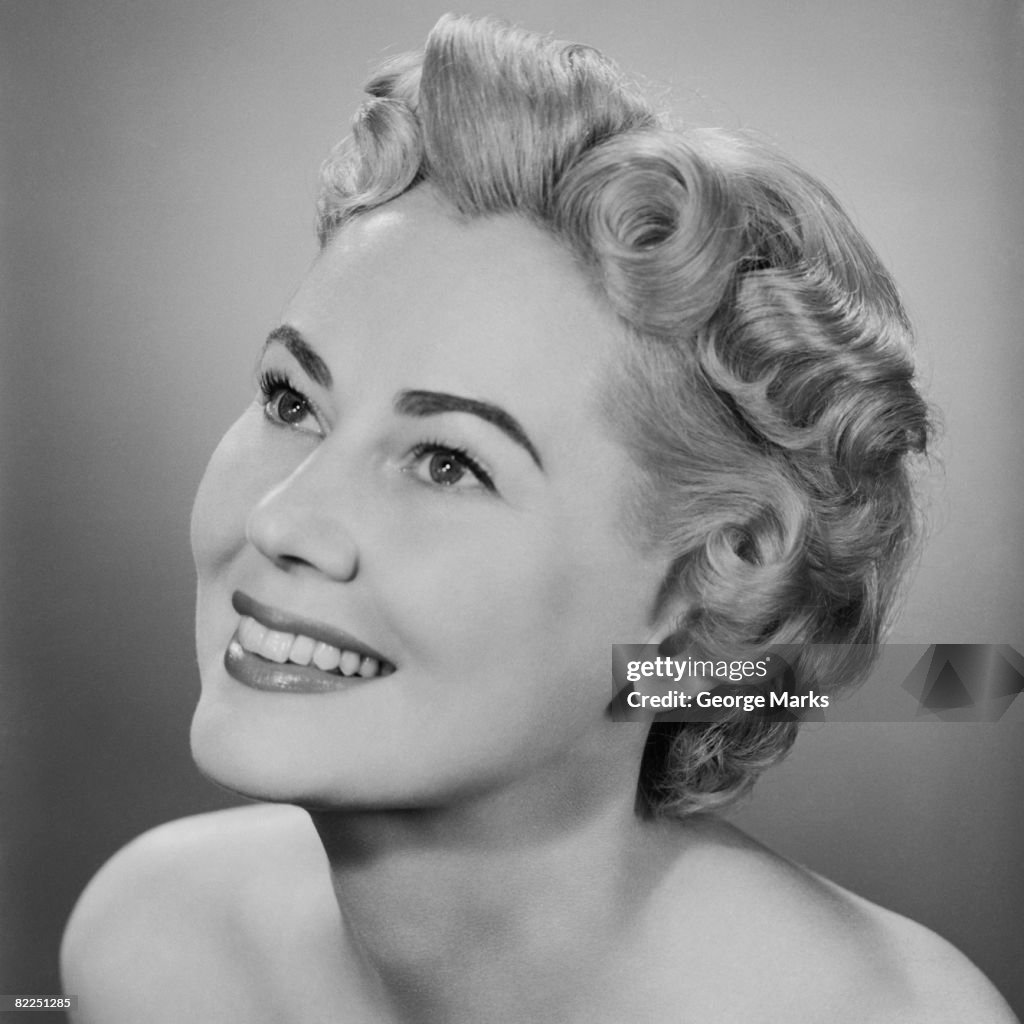 Studio shot of mid adult woman looking up