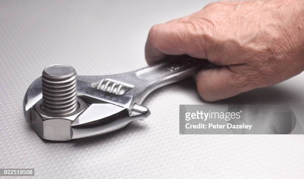 hand using adjustable spanner to tighten/loosen a nut on a bolt - screw stock pictures, royalty-free photos & images