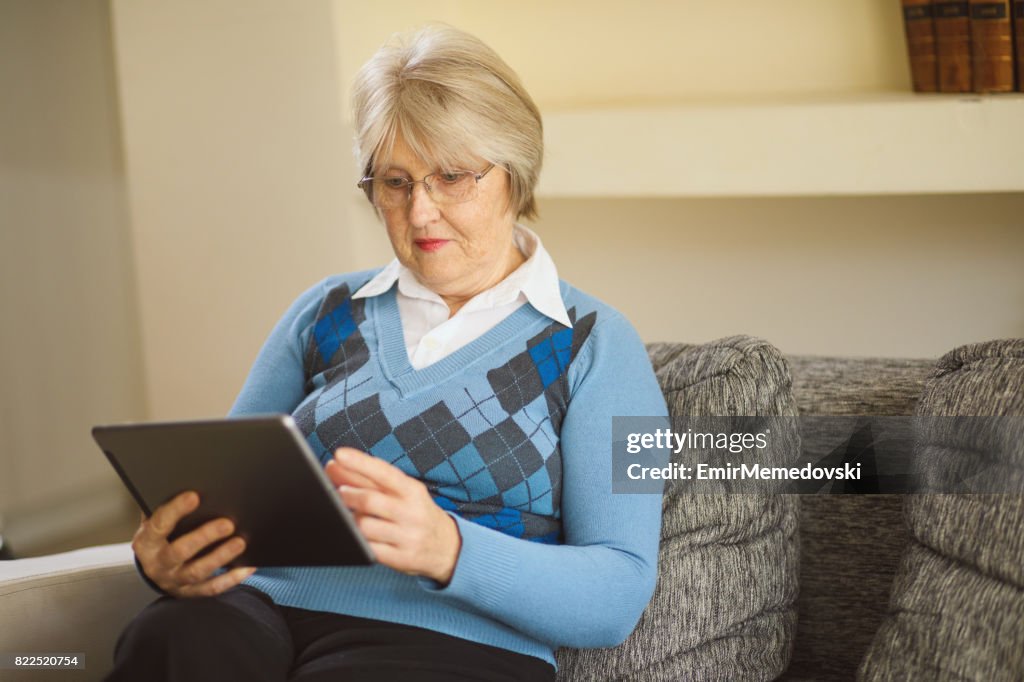 Senior Frau mit tablet PC zu Hause