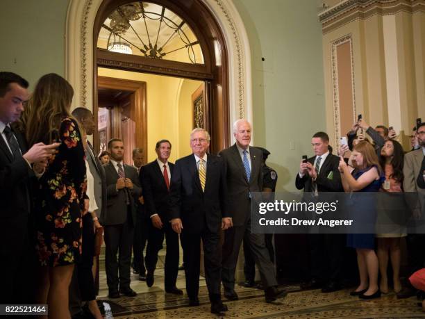 Sen. John Barrasso , Senate Majority Leader Mitch McConnnell and Sen. John Cornyn emerge from the Senate Chamber following a procedural vote to open...