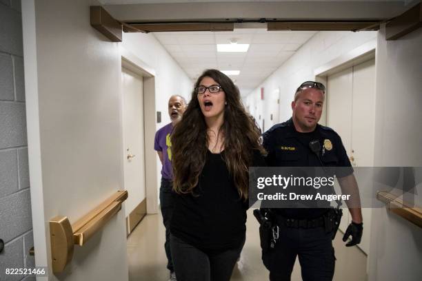 Protestors, who were removed from the Senate Chamber while protesting the GOP health care plan, are escorted out by U.S. Capitol Police officers on...