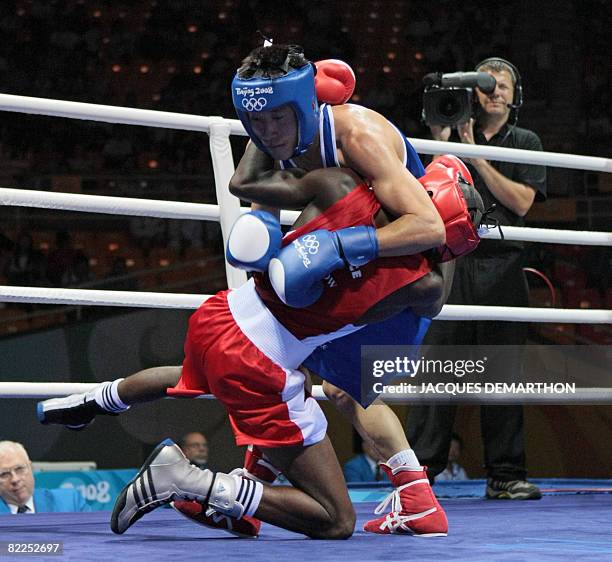 France's Daouda Sow and DPR of Korea's Song Guk Kim hit the canvas during their 2008 Olympic Games Lightweight boxing match on August 11, 2008 in...