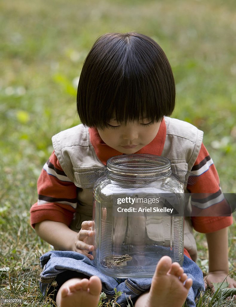 Young Asian Boy Looking at Frog in Jar