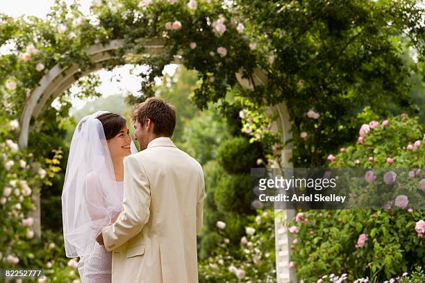 young couple getting married in garden - trouwerij stockfoto's en -beelden