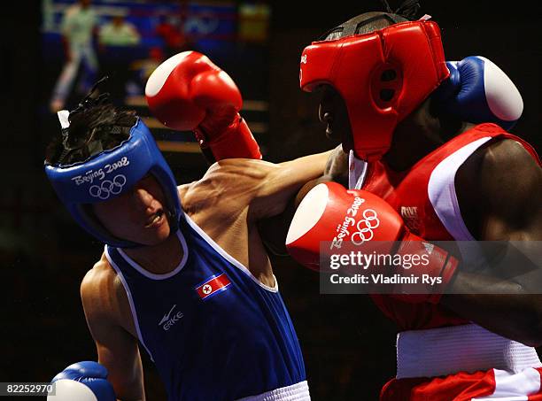 Kim Song Guk of Korea exchanges punches with Daouda Sow of France during their men's 60kg light weight bout in the boxing event at the Workers Indoor...