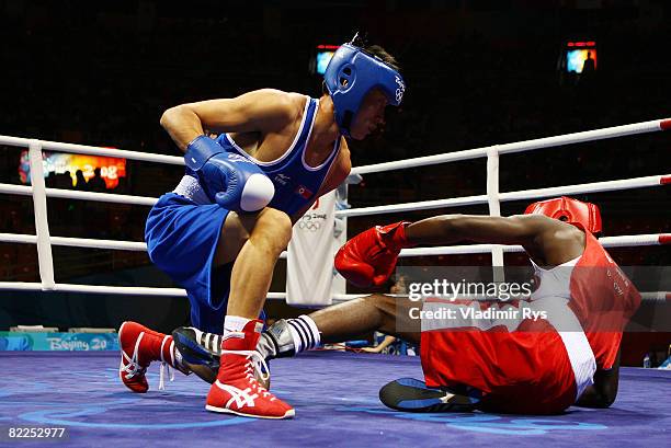Kim Song Guk of Korea falls to the canvas along with Daouda Sow of France during their men's 60kg light weight bout in the boxing event at the...
