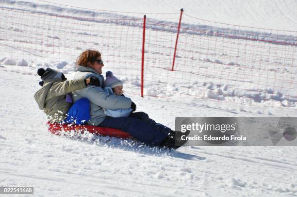 mother, daughter and son on a red bob - scary ski slope stock pictures, royalty-free photos & images